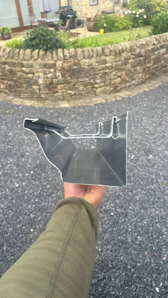 Hand-held cross-section of the aluminium gutter profile