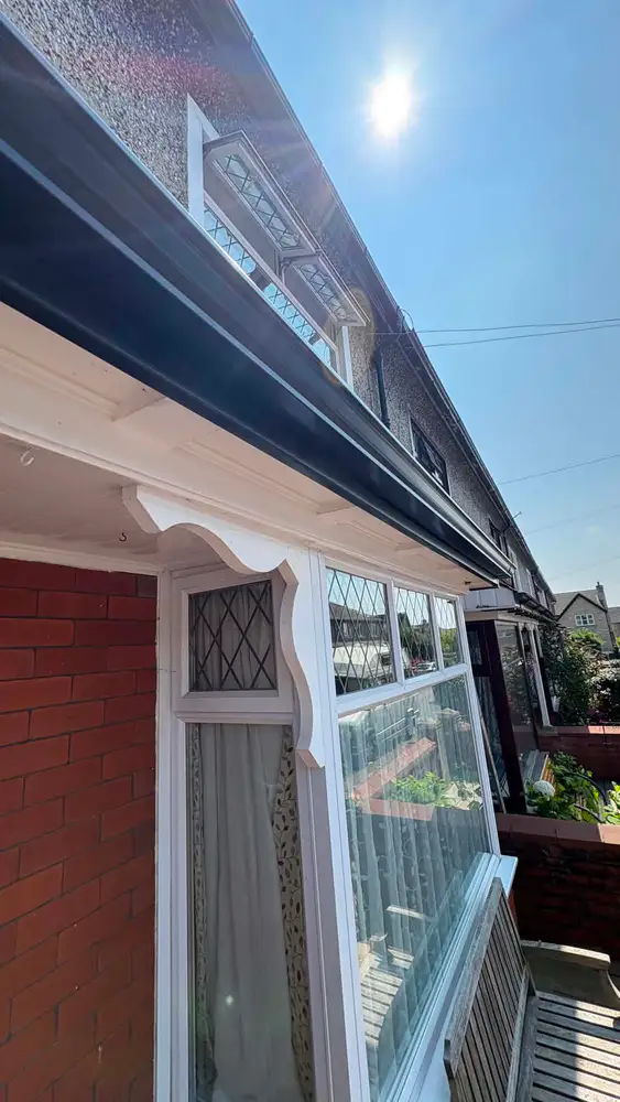 Black aluminium gutter system with a clean white fascia
