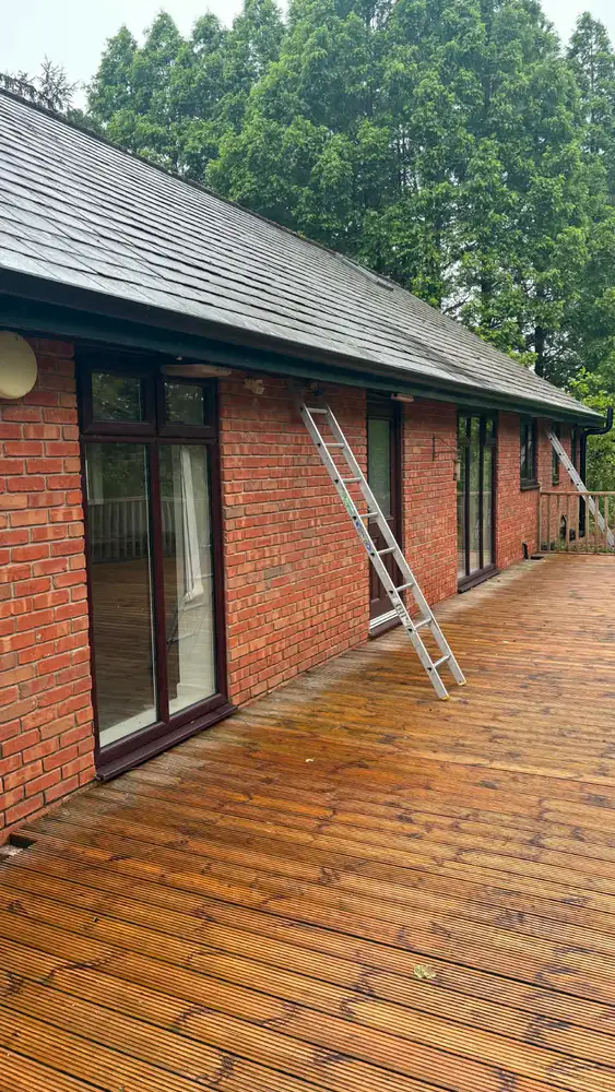 Long run of black seamless guttering fitted to a brick bungalow
