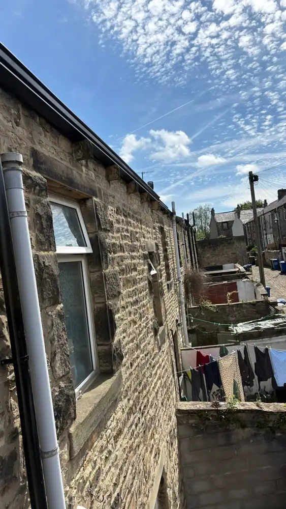 Back exterior of a stone terrace house with completely new roofline