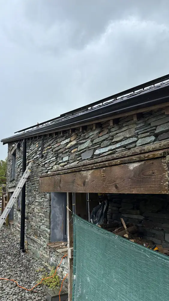 Black seamless guttering fitted to a renovated stone barn
