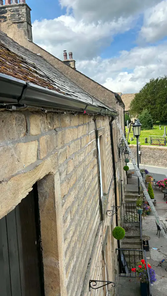 Black guttering fitted to a traditional stone building